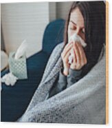 Sick Woman Blowing Her Nose, She Covered With Blanket Wood Print