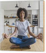 Smiling Woman With Closed Eyes In Yoga Pose On Table At Home Wood Print