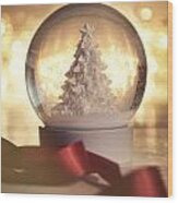 Snow Globe Against A Warm Holiday Background Wood Print