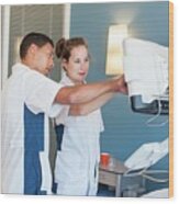 Two Nurses Checking Monitor On Hospital Bed Wood Print