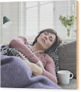 Woman With Stomach Ache Lying On The Sofa Wood Print