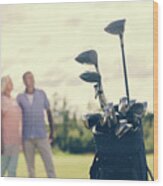 Golf Bag Standing On A Grass Field, People In The Background Wood Print