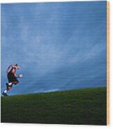 Athlete Running Up Grassy Hill Wood Print