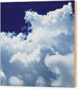 Billowing Masses Of Cumulus Clouds Against A Dark Blue Sky Wood Print