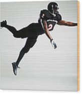 Football Player Leaping In Mid Air To Wood Print