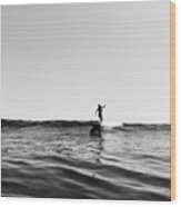 Pulled Back View Of A Female Surfer Riding Small Wave, Black And White Wood Print