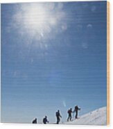Skiers Ascending An Alpine Slope Wood Print