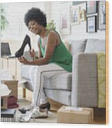 African American Woman Opening Packages Of Shoes On Sofa Wood Print