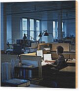 Businesswoman Examining Documents At Desk At Night Wood Print