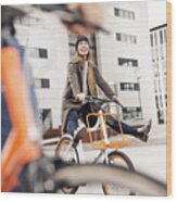 Carefree woman with man riding bicycle in the city Wood Print