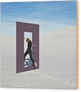 Cheerful Young Woman Jumping Through Door Frame At Desert Wood Print
