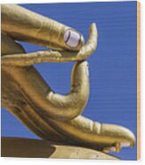 Close Up Of Golden Hand Statue Against Blue Sky Wood Print
