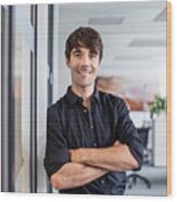 Confident Businessman Leaning On Wall In Creative Office Wood Print