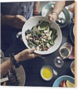 Cropped Image Of Friends Holding Salad Bowl At Table Wood Print