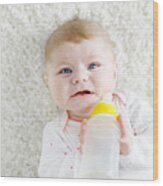 Cute Adorable Ewborn Baby Girl Holding Nursing Bottle And Drinking Formula Milk Wood Print