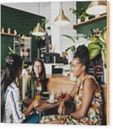 Group Of Girls Sitting In Coffee Shop Chatting Wood Print