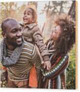 Happy Black Parents Having Fun With Their Daughter At The Park. Wood Print