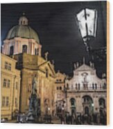 Historic Buildings Beneath The Tower Of Charles Bridge In The Night In Prague In The Czech Republic Wood Print
