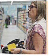 Mature Woman Shopping In Supermarket. Wood Print