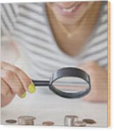 Mixed Race Woman Examining Stacks Of Coins With Magnifying Glass Wood Print
