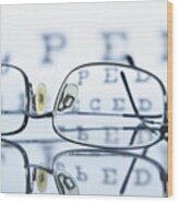 Myopic Spectacles With A Snellen Eye Chart In The Background Wood Print