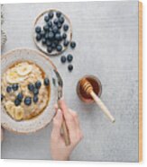 Oatmeal Porridge Bowl With Blueberries In Female Hands Wood Print