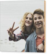 Portrait Of Happy Teenage Couple Showing Victory-sign Wood Print