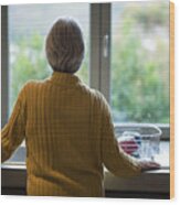 Senior Woman Standing Near The Kitchen Sink And Looking Through Window Wood Print