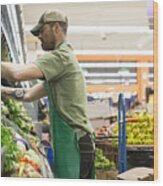 Side View Of Worker Arranging Vegetables On Shelves At Supermarket Wood Print
