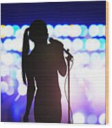 Silhouette of woman with microphone singing on concert stage in front of crowd Wood Print