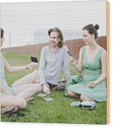 Three Young Adults Looking Their Instant Pictures Wood Print