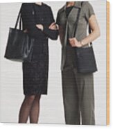 Two Beautiful  Young Caucasian Women With Shoulder Length Blond Hair Dressed In Businees Attire And Purses Standing Together Smiling Into The Camera Wood Print