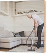 Woman Cleaning Carpet With A Vacuum Cleaner In Room Wood Print