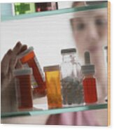 Woman Taking Pills From Medicine Cabinet Wood Print