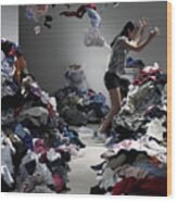 Woman Throwing Clothes In Overflowing Laundry Room Wood Print