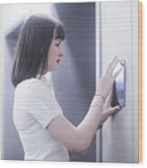 Woman Using Wall Mounted Touch Screen Control Panel Wood Print