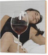Young Woman Sleeping With Wineglasses In Front Of Her Wood Print