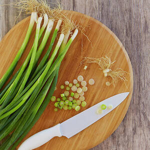 Spring Onions On Chopping Board by Colin Anderson Productions Pty Ltd