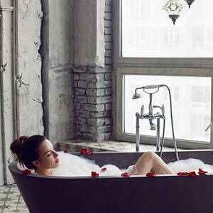 Sexy Young Beautiful Girl Is Lying In A Stone Gray Large Bathroom