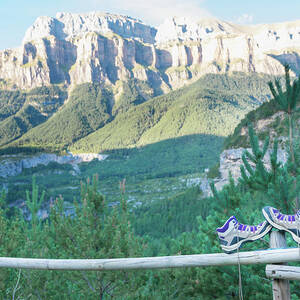 A Pair Of Boots Untied Up And Abandoned On A Wooden Railing And Leaning On A Post. The Hiker Has Put Out His Boots To Rest His Feet After Hiking For A Time. Horizontal Photo With Nobody. by Cavan Images