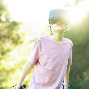 Tween Having Virtual Experience With Vr Goggles Outside In Green Field by Cavan Images