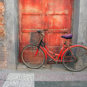 Red Bike in Front of Red Door in Europe by Matthew Bamberg